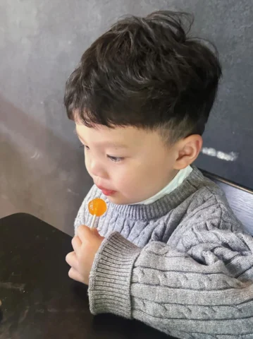 Bé trai với mái tóc xoăn đẹp
