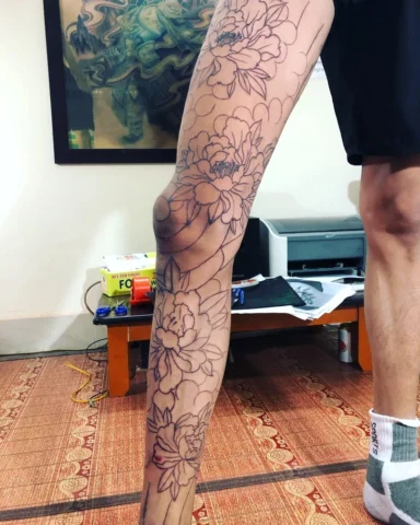 Hình xăm hoa mẫu đơn ở bắp chân với phong cách màu nước