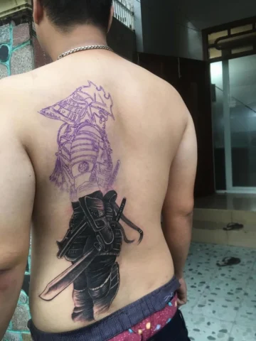 Hình xăm nửa lưng samurai với các yếu tố truyền thống như hoa anh đào và sóng
