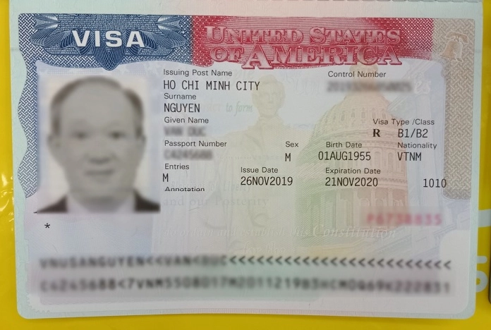 Visa Mỹ Miễn Visa Nước Nào? Cập Nhật 2026 Người mang visa Mỹ đang xem bản đồ thế giới