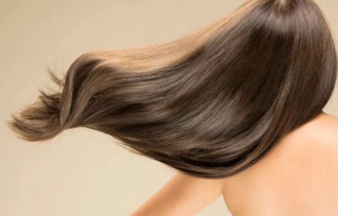 Người phụ nữ chăm sóc tóc với sản phẩm dưỡng tóc