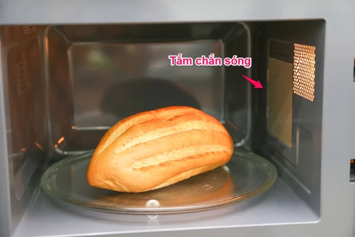 Lò Vi Sóng Không Nóng: Nguyên Nhân & Cách Khắc Phục Nhanh Chóng 2026 Thợ sửa chữa đang kiểm tra linh kiện bên trong lò vi sóng